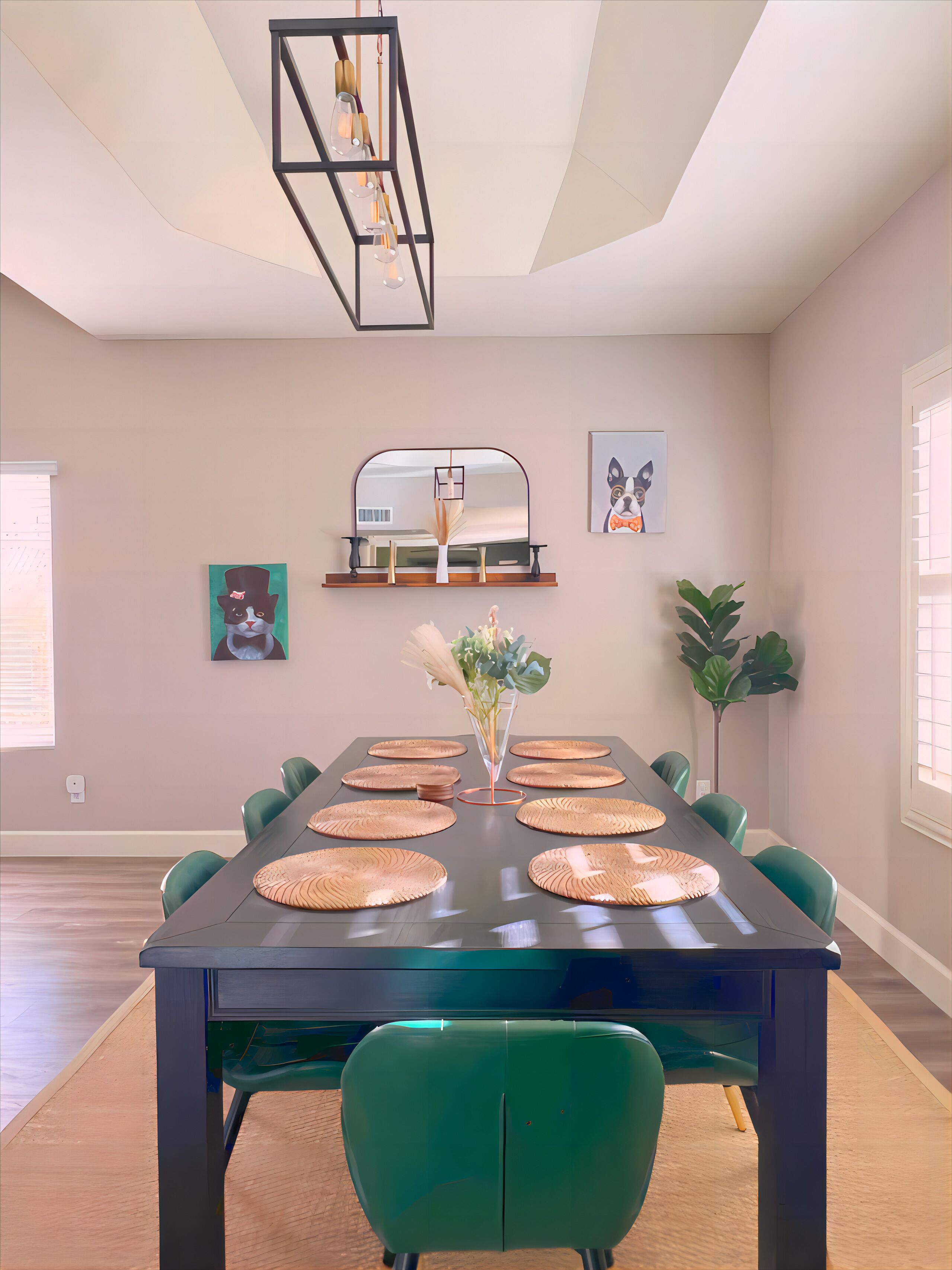 A dining area with a long table, green chairs, and a modern chandelier.
