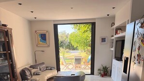 Eine moderne Küche mit Essbereich, einer Couch und einem Glastisch.