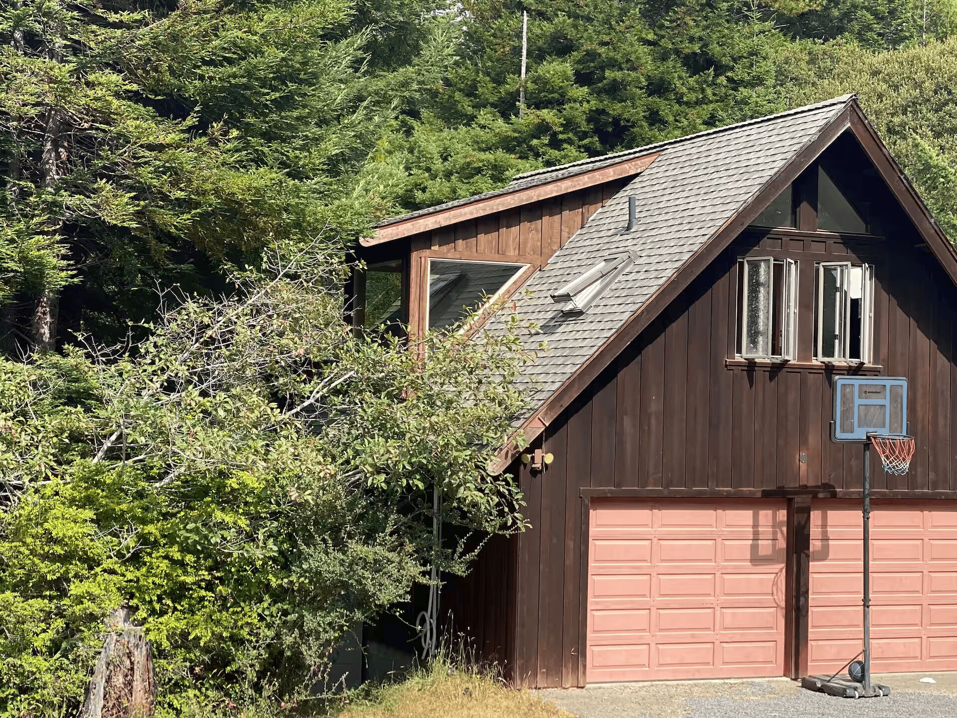 Un bâtiment en bois avec un garage, une fenêtre et une porte.