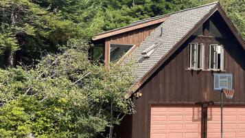 Un bâtiment en bois avec un garage, une fenêtre et une porte.