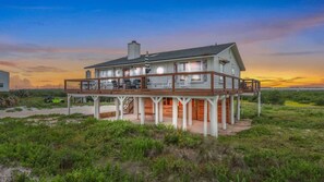 Ein zweistöckiges Strandhaus mit Balkon, Terrasse und Meerblick.