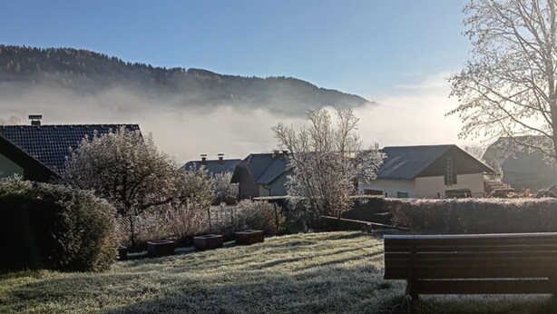 A residential area with houses, a bench, and a hill in the background. - Eden Apartment (Glödnitz)
