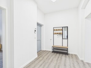 A hallway with a coat rack, a bench, and a door. - Family apartment with balcony, up to 5 guests - GÖ08 (Görlitz)