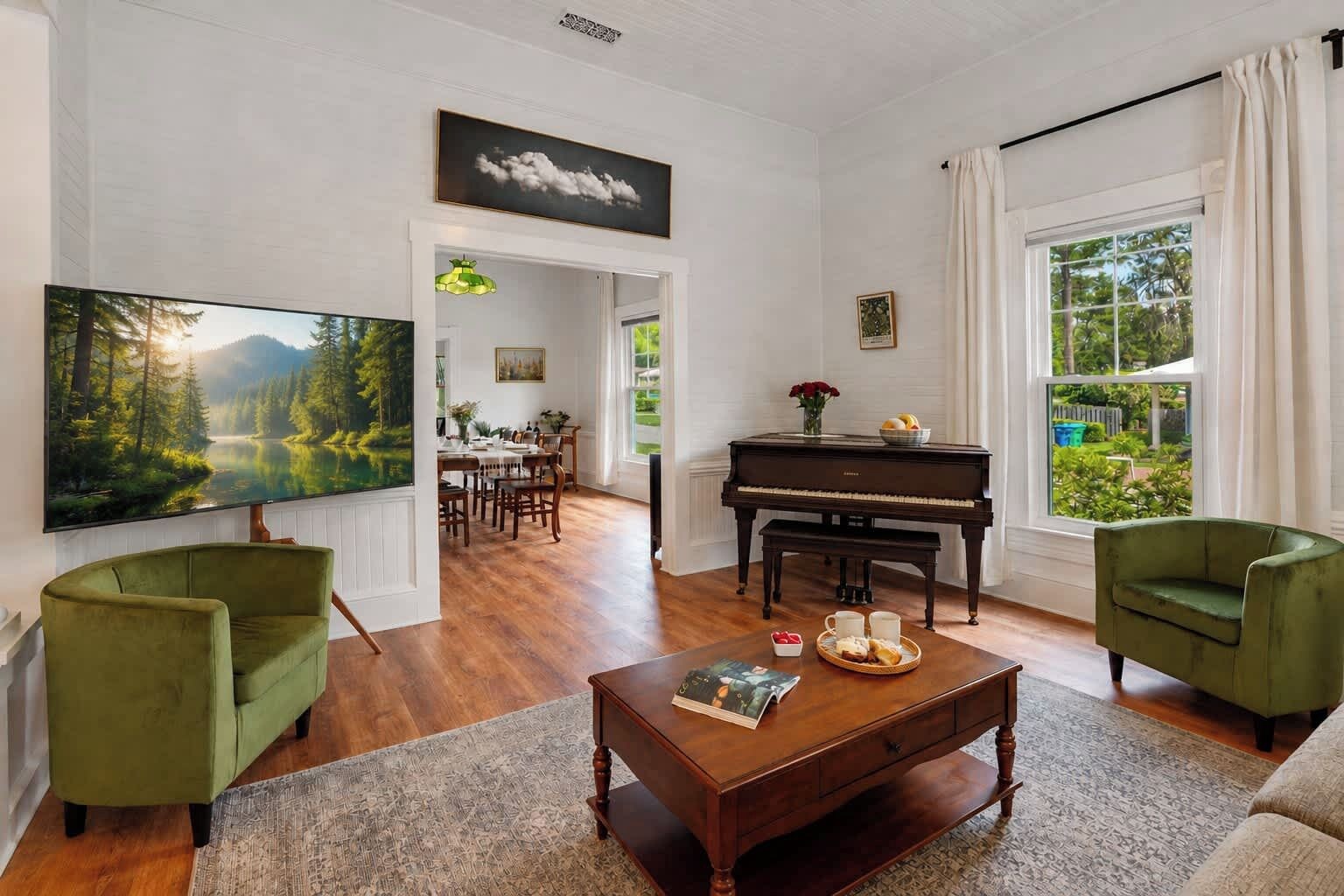 A living room with a piano, a television, and a dining area with a table and chairs.