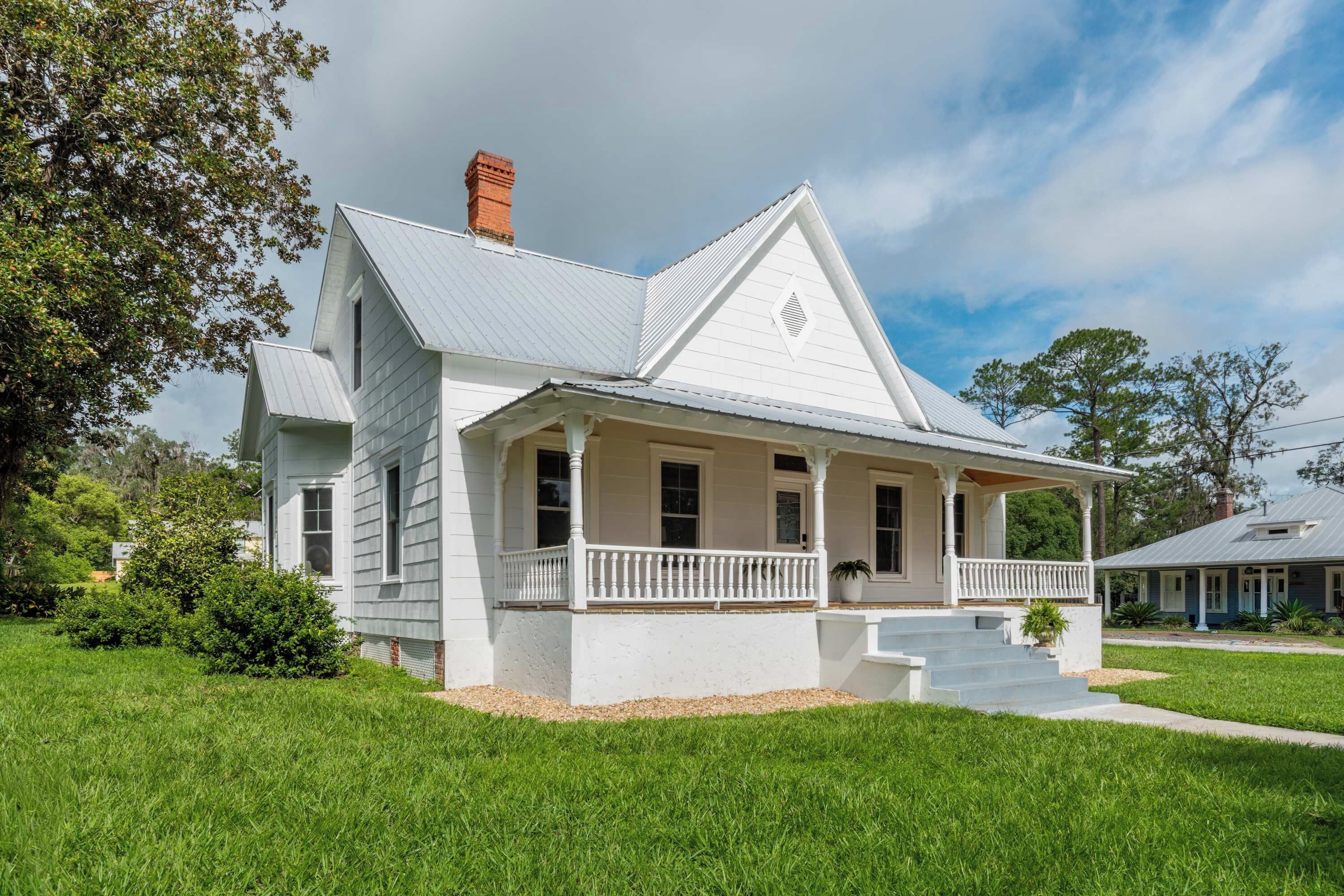A two-story house with a porch and a chimney.