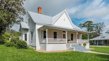 A two-story house with a porch and a chimney.