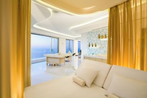Ein modernes Hotelzimmer mit einem großen Bett, einem Schminktisch und Blick aufs Meer.