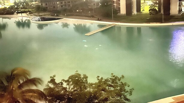 A swimming pool with a view of buildings in the background. - Dreams Lagoon (Cancún)