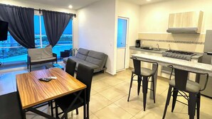 A modern apartment with a dining area, kitchen, and a sofa. - Dreams Lagoon (Cancún)