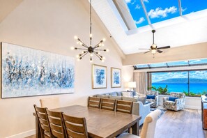 A spacious living area with a high ceiling, a dining table, and seating arrangements. - Sands Of Kahana Oceanfront 3-Bedroom Penthouse | Car Incl w/ 6 nights | SOK-381 by KBM (Lahaina)