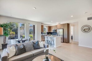 A modern living room with a sofa, coffee table, and a view of the outside.