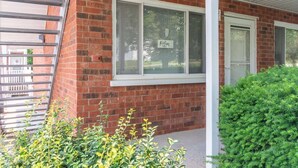 Un edificio de ladrillo con una ventana que muestra la palabra 'Relax' y una puerta blanca.