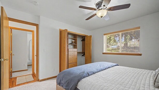 A bedroom with a bed, a ceiling fan, a wardrobe, a window with blinds, and a door. - Riverfront Ski & Fish Condo, Near BC & Vail (Edwards)