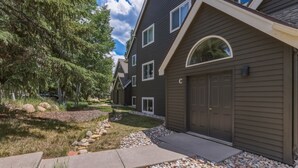 A residential building with a dark exterior, multiple windows, and a garage. - Riverfront Ski & Fish Condo, Near BC & Vail (Edwards)