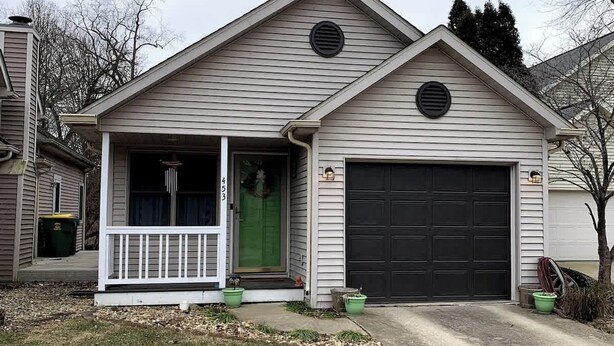A single-story house with a front porch, a garage, and a small front yard.