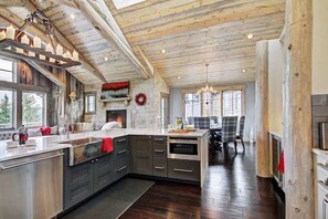 A spacious kitchen with a large island, wooden ceiling beams, and a fireplace. - Luxury Mountain Estate wHot Tub Sauna & Movie Room (Breckenridge)