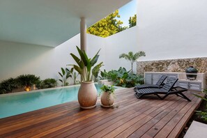A wooden deck with a pool, lounge chairs, and a grill. - Casa del Paseo| Rooftop Bar + 2 Pools near Montejo (Mérida)