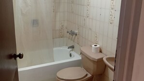 Un baño con bañera, inodoro y lavabo.