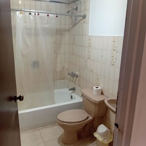 A bathroom with a bathtub, toilet, and sink. - Apartment in la esperilla (Santo Domingo)