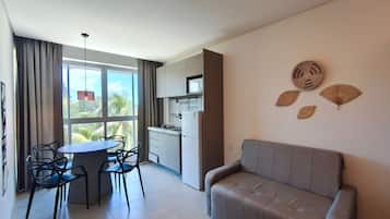 A modern kitchen with a dining area, a sofa, and decorative wall art.