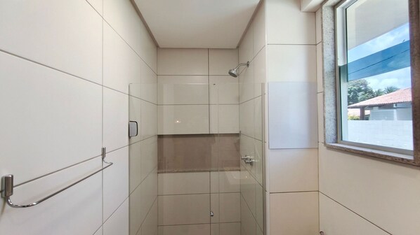 A small, tiled bathroom with a shower, a window, and a towel rack. - Mila Rooftop - Praia de Tamandaré (Tamandaré)