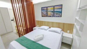 A hotel room with a bed, a nightstand, a wall-mounted painting, and a curtain. - Mila Rooftop - Praia de Tamandaré (Tamandaré)
