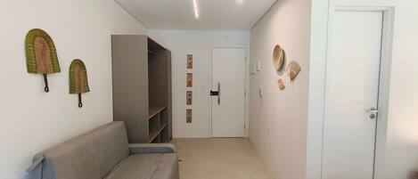 A hallway with a sofa, a wardrobe, and a door.