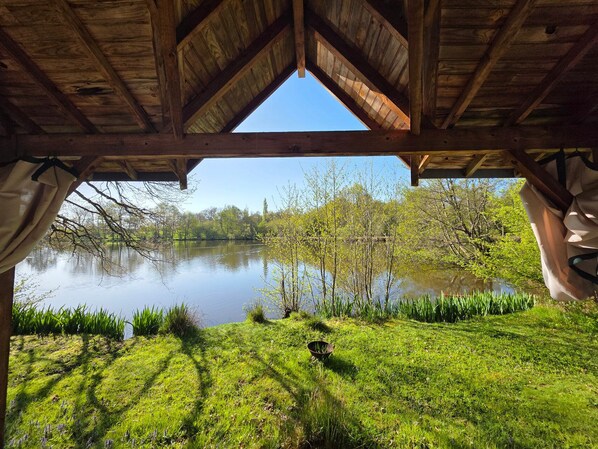Une structure en bois offrant une vue sur un lac et la végétation environnante.