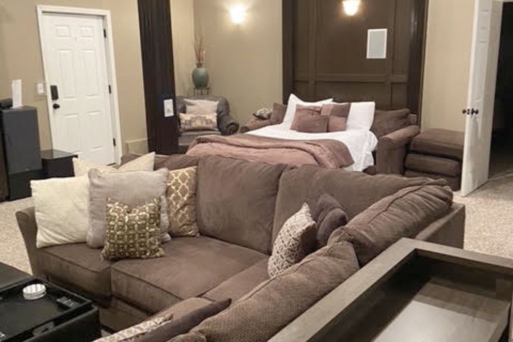 A bedroom with a large bed, a sofa, and a small table.