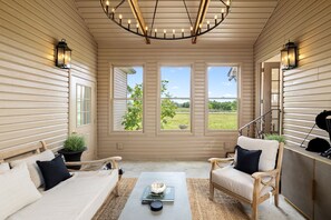 A room with a bed, two chairs, a coffee table, and a view of greenery outside. - The Porch on Puckett Lane, peaceful countryside escape in Nolensville (Nolensville)