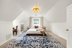 A bedroom with a large bed, a chandelier, a window with curtains, and a patterned rug. - The Porch on Puckett Lane, peaceful countryside escape in Nolensville (Nolensville)