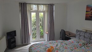 A bedroom with a bed, a desk, and a television. - 6 Bed House Sleeps 13 - Private Garden (Bristol)