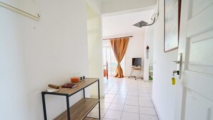 Um corredor com uma mesa de madeira, uma televisão e uma porta com fechadura.