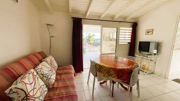 Apartamento executivo, suíte, vista para o mar | Área de estar | TV LED 32 polegadas com canais digitais