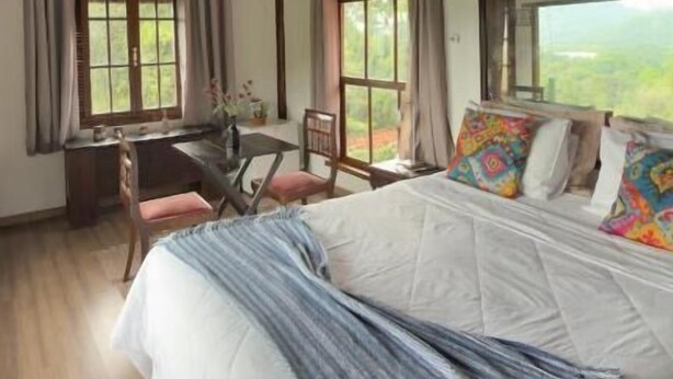 Ein Zimmer mit Bett, Schreibtisch und Fenster.