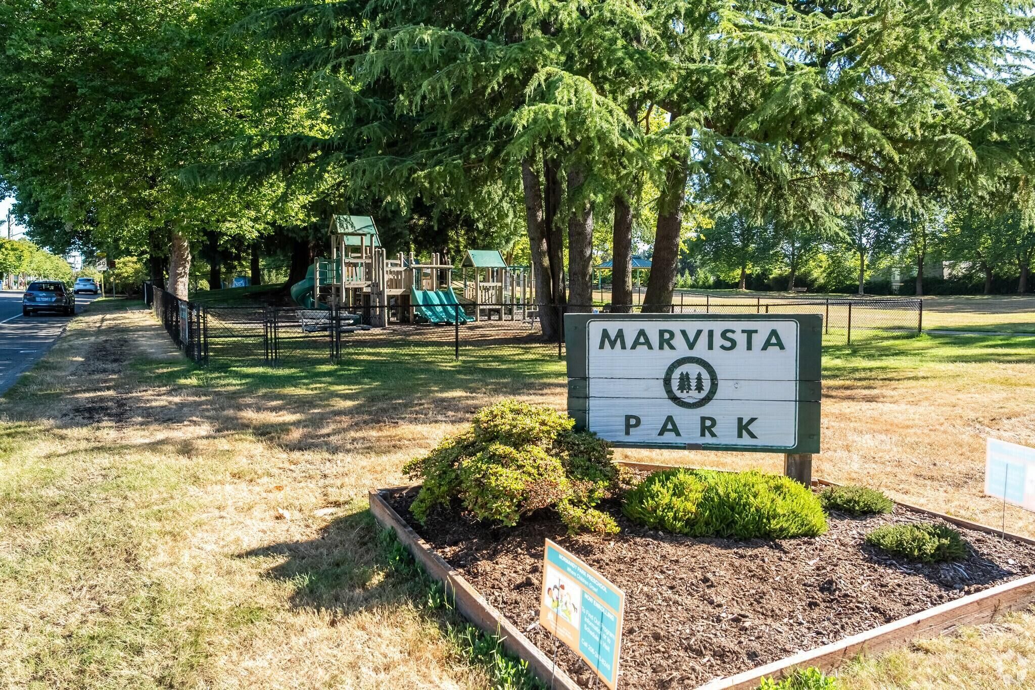 Placa de parque com 'MARVISTA PARK' e um parquinho ao fundo.