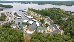 A marina with docked boats, a swimming pool, and a building complex with multiple floors and balconies. - Lakefront living with stunning views and easy pool access, Open-concept space,Close to everything (Lake Ozark)