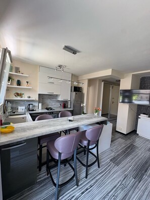A modern kitchen with a marble countertop, stainless steel appliances, and a dining area with bar stools. - Fabulous 1-bedroom apartment with AC in vibrant Nice (Nice)