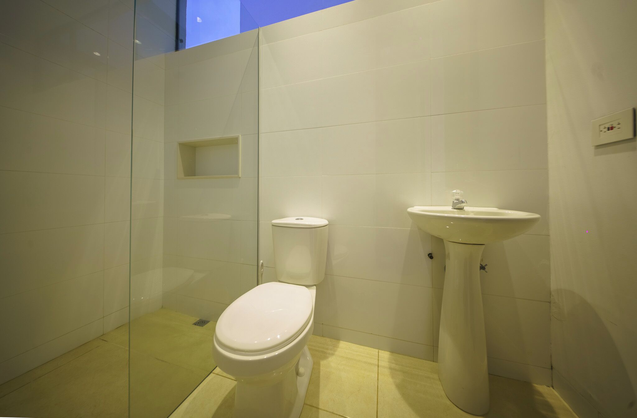 Un bagno piccolo e moderno, con il water e un lavabo su piedistallo.