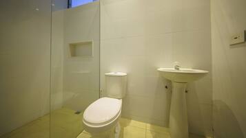 Un bagno piccolo e moderno, con il water e un lavabo su piedistallo.