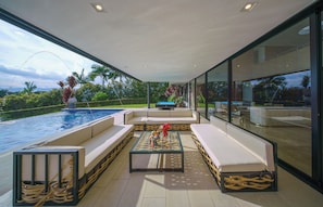 Un moderno espacio exterior de descanso con piscina, asientos y mesa de billar.