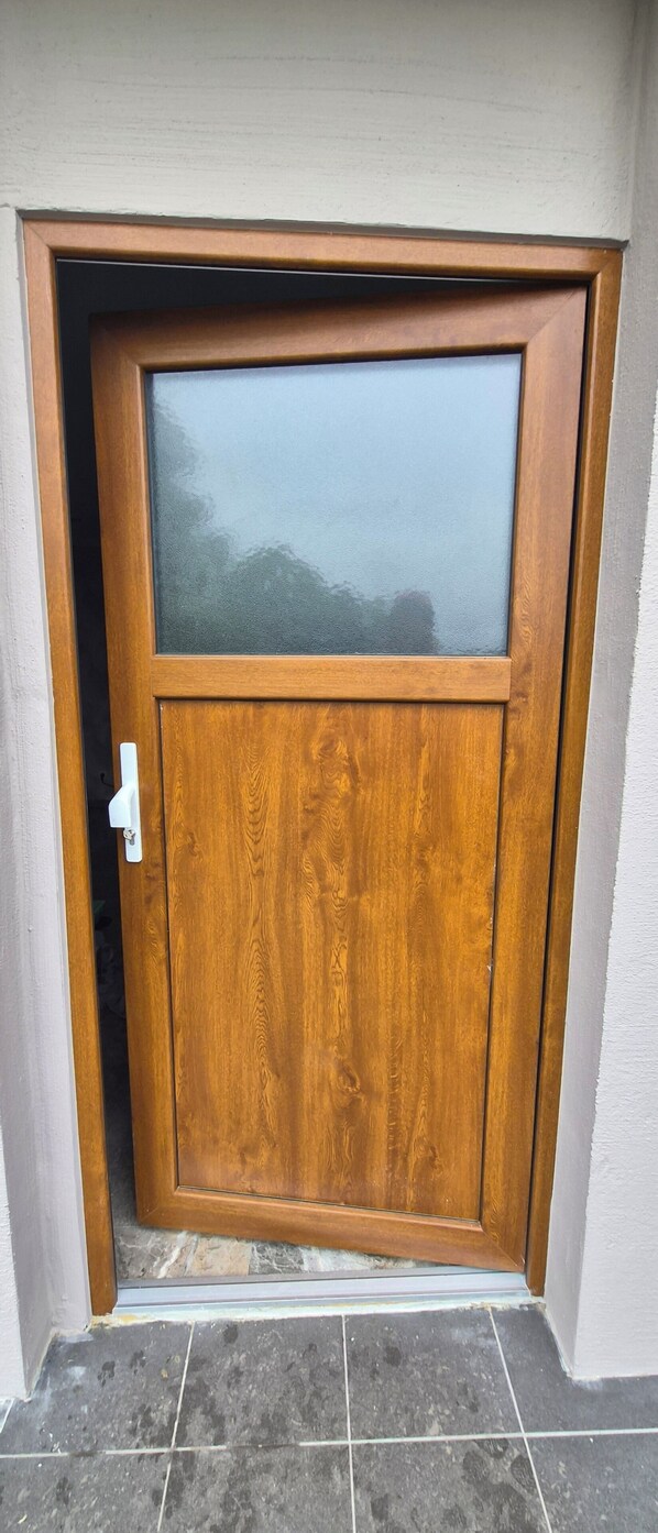A wooden door with a frosted glass panel and a white handle.