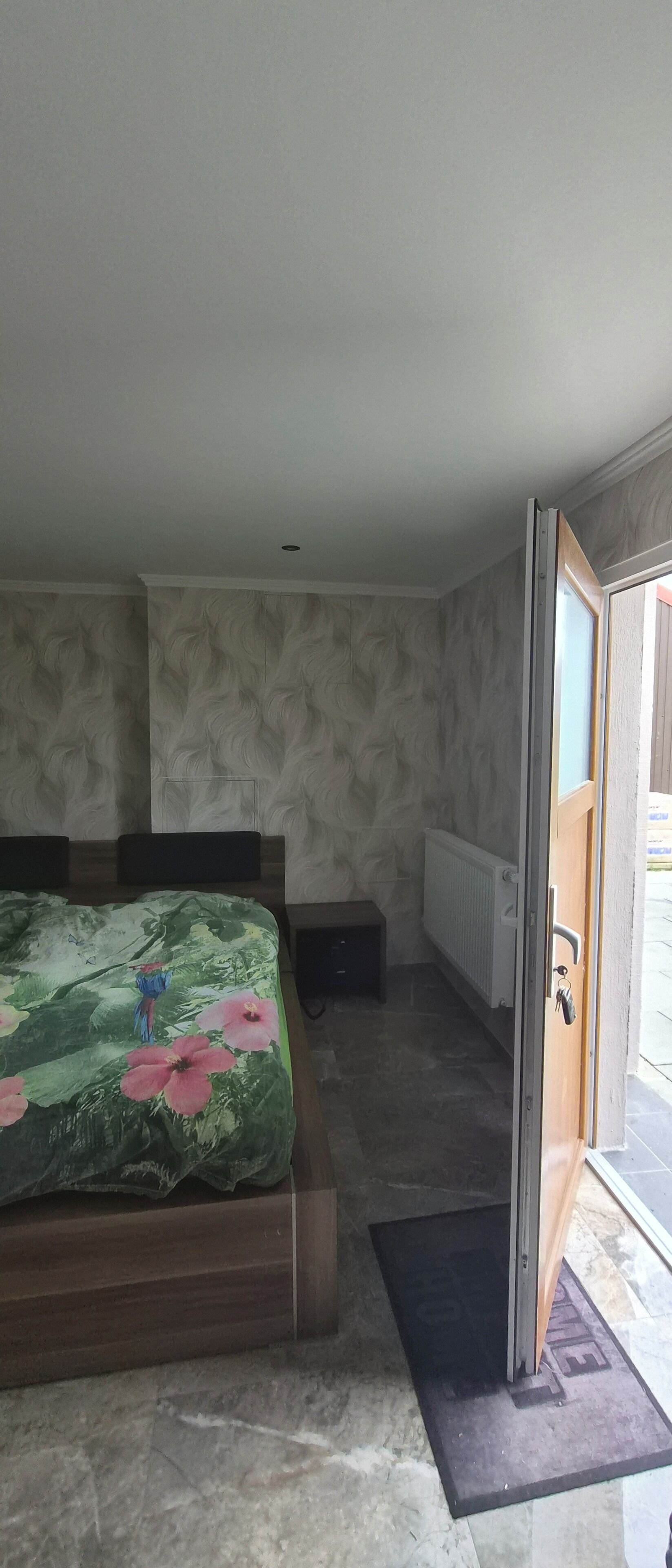 Una camera da letto con un letto, un termosifone, una porta e una vista attraverso la porta.