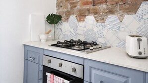A kitchen with a gas stove, a toaster, and a brick wall backsplash. - OVERSIZED, CONTEMPORARY & CHARMING-GREAT VALUE!3min train to CBD/Shared Parking. (Darlinghurst)
