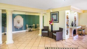 A spacious lobby with a dining area, a fireplace, and a fountain.