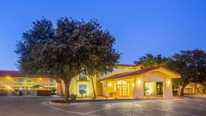 A hotel with a courtyard, a covered entrance, and a building with multiple floors.