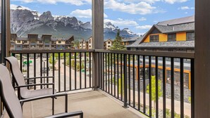 A balcony with a view of mountains and a road. - 1650 sq ft 2BR Corner Condo 303 (Canmore)