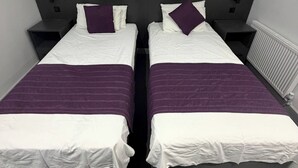 A double bed with white and purple bedding, two nightstands, and a black headboard. - Commercial Hotel - Standard Twin Room Shared (Middlesbrough)