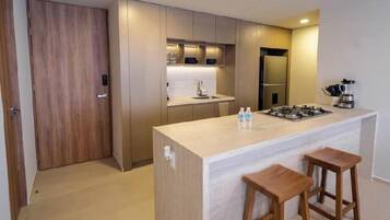 Cozinha moderna com ilha central, banquetas e eletrodomésticos embutidos.