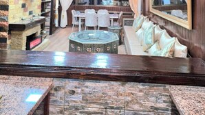 Un intérieur luxueux agrémenté d’un grand lustre, d’un mur en pierre, d’un coin salon et d’un téléviseur.
